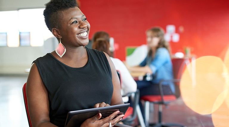 201612_CCS_BlogIMG_Marketing-a-Franchise-How-to-Get-Started Black female entrepreneur smiling while holding a tablet