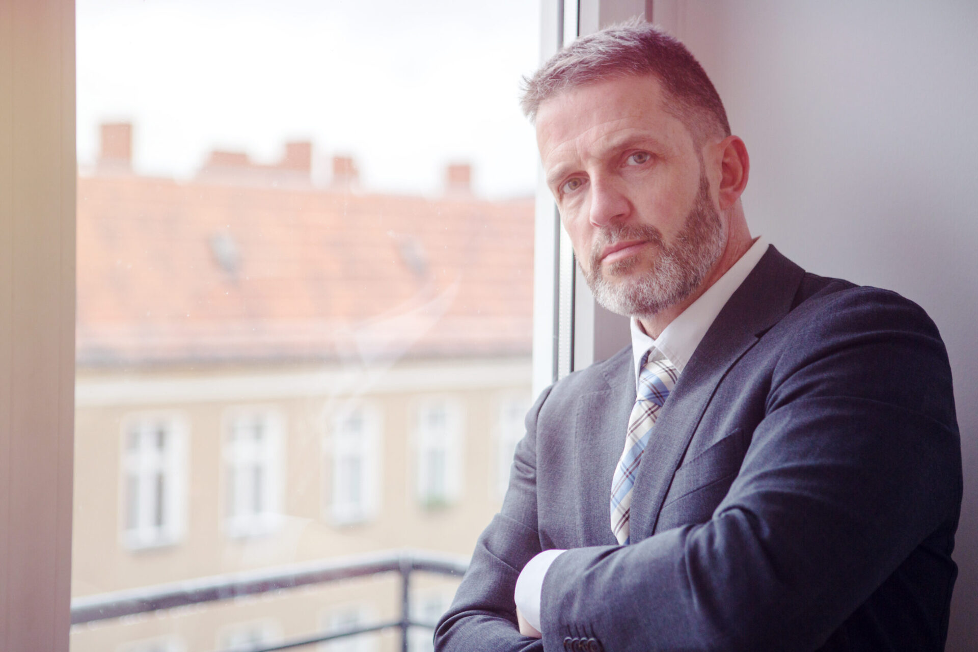 handsome businessman standing by the window portrait of handsome businessman standing by the window
