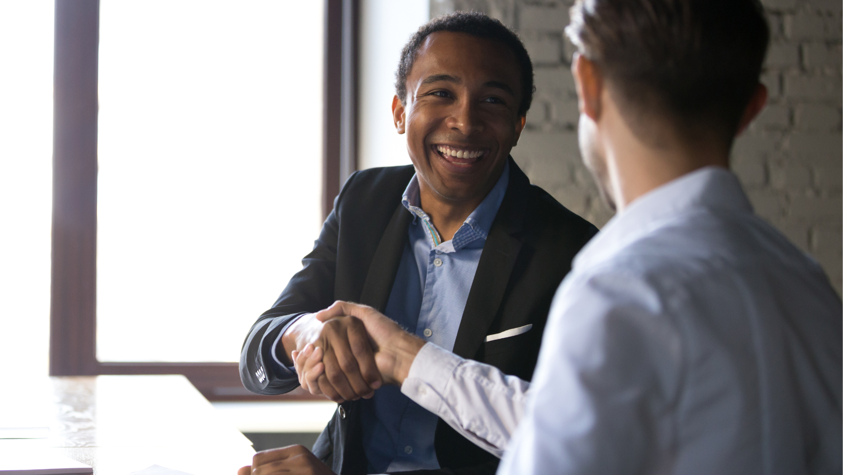 Blog20Covers20285629 African American entrepreneur shaking hands with another young entrepreneur in an office setting
