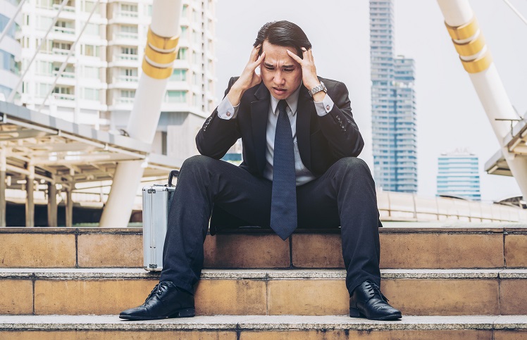 Desperate Businessman Sitting Hopelessly On Stair Floor Desperate businessman sitting hopelessly on stair floor in central business district due to unemployment.