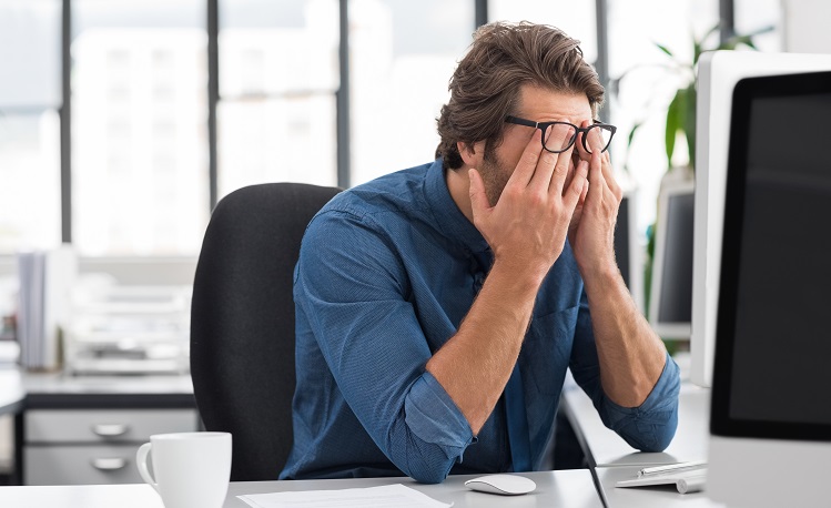 Stressed young businessman at a desk