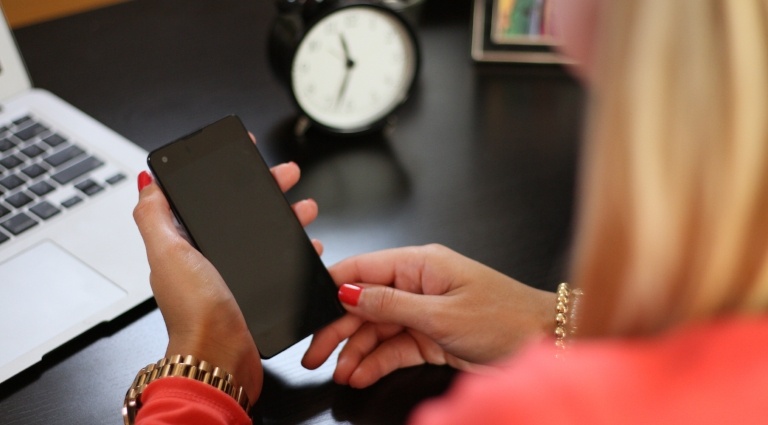 Female professional at her desk and looking at her phone