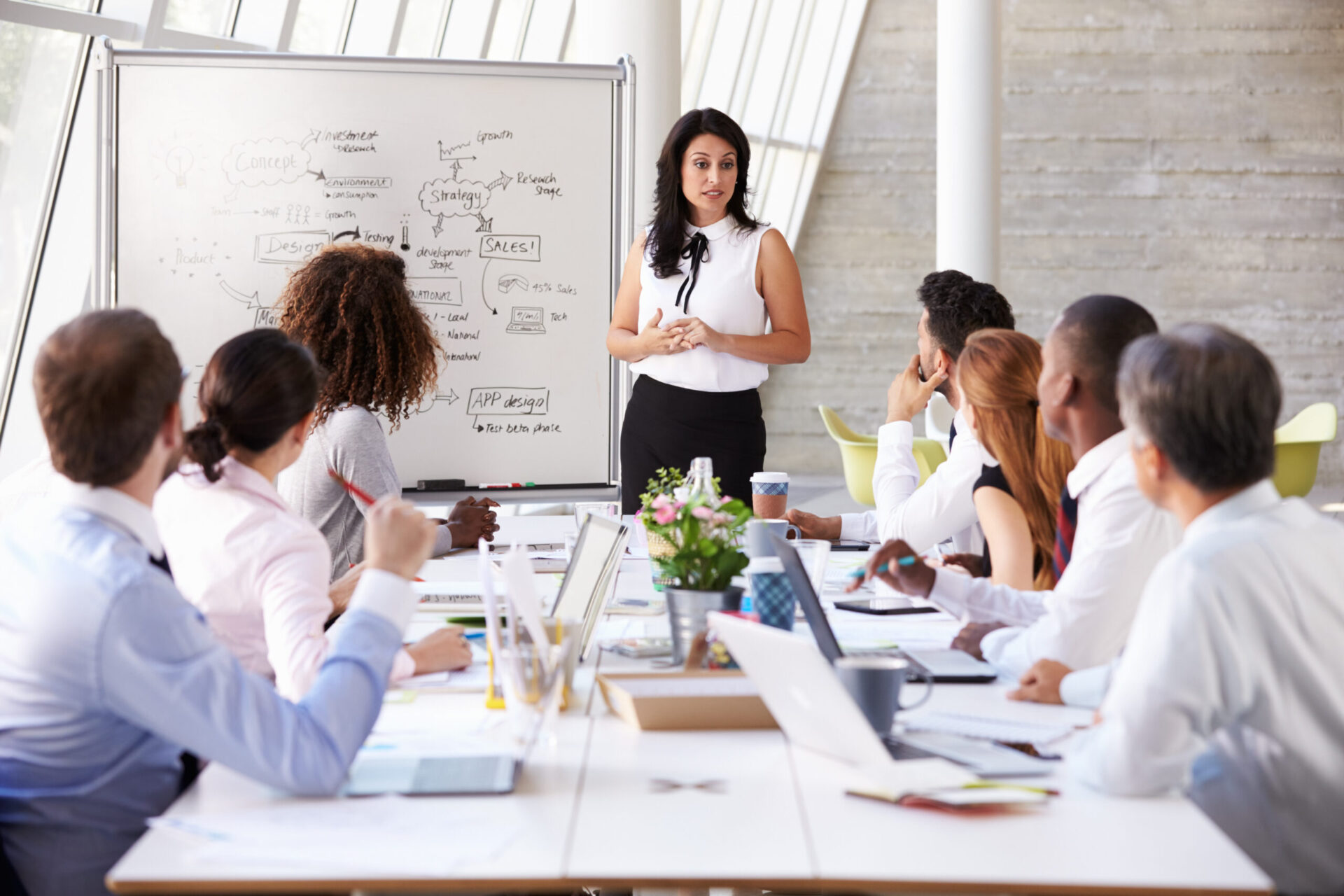 Hispanic Businesswoman Leading Meeting At Boardroom Table Hispanic Businesswoman Leading Meeting At Boardroom Table