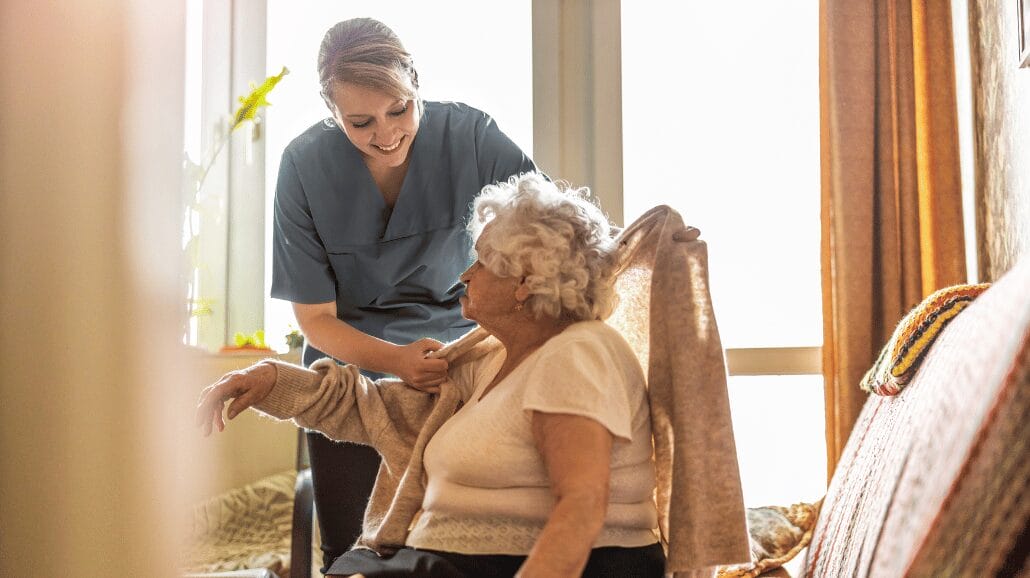 Blog Covers – 2024-10-10T073210.928 Caregiver helping a senior get dressed at home