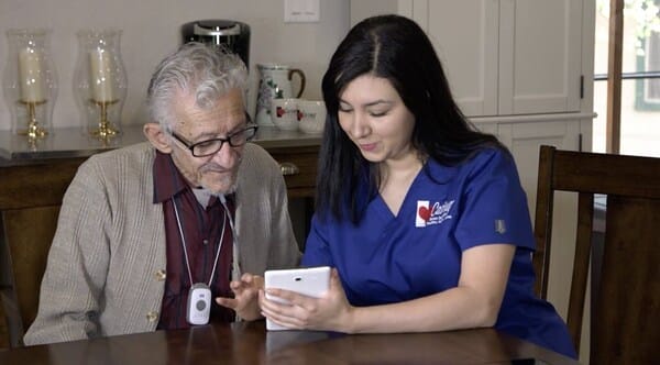 Caregiver assisting a senior with a tablet