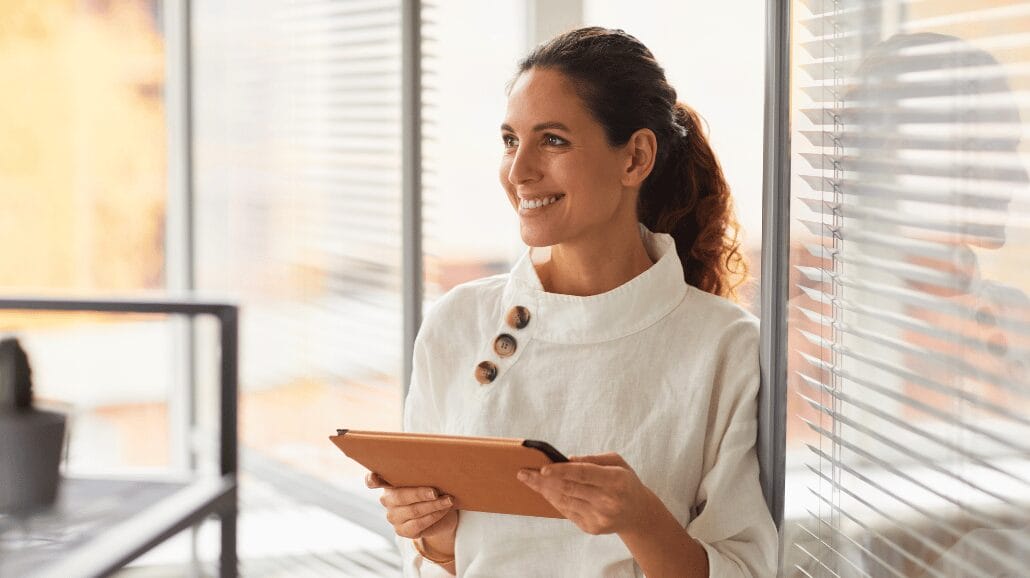 Female entrepreneur smiling and holding a tablet
