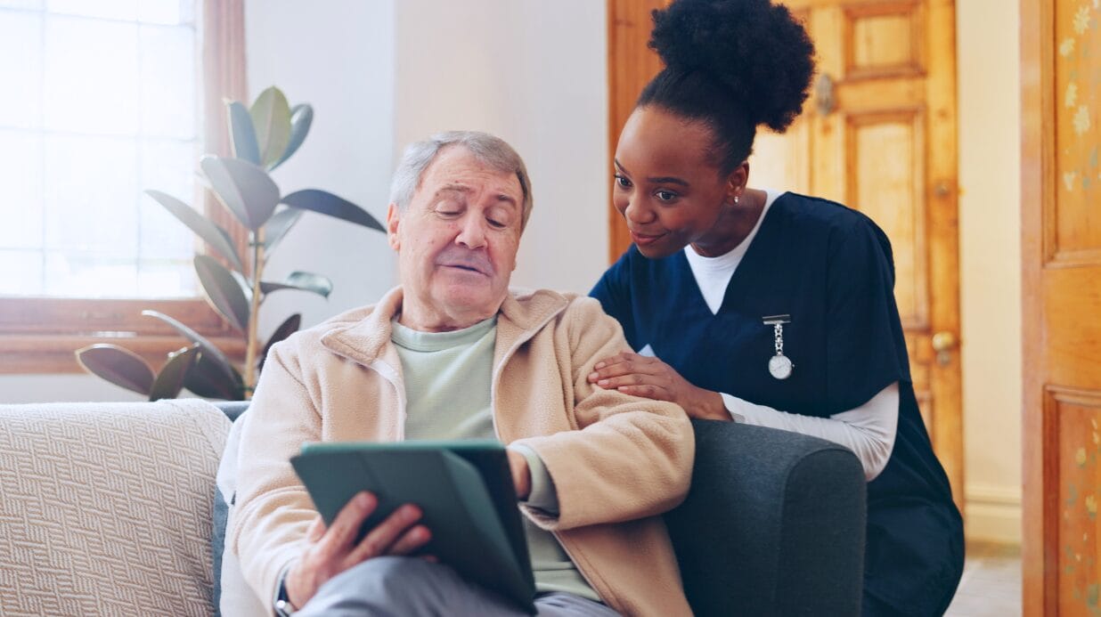 Blog Covers (42) Caregiver assisting an elderly man with a tablet